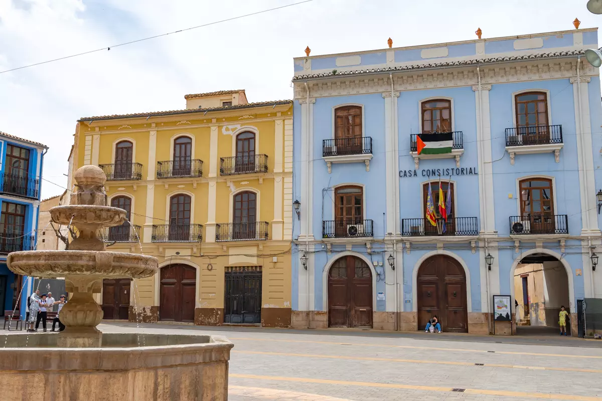 Main square of Chelva with colorful facades and the church tower.