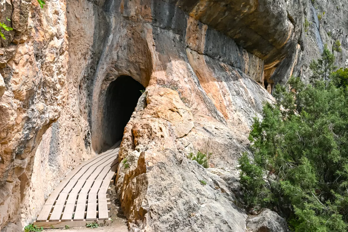 Narrow tunnel carved into rock along the aqueduct trail near Chelva.