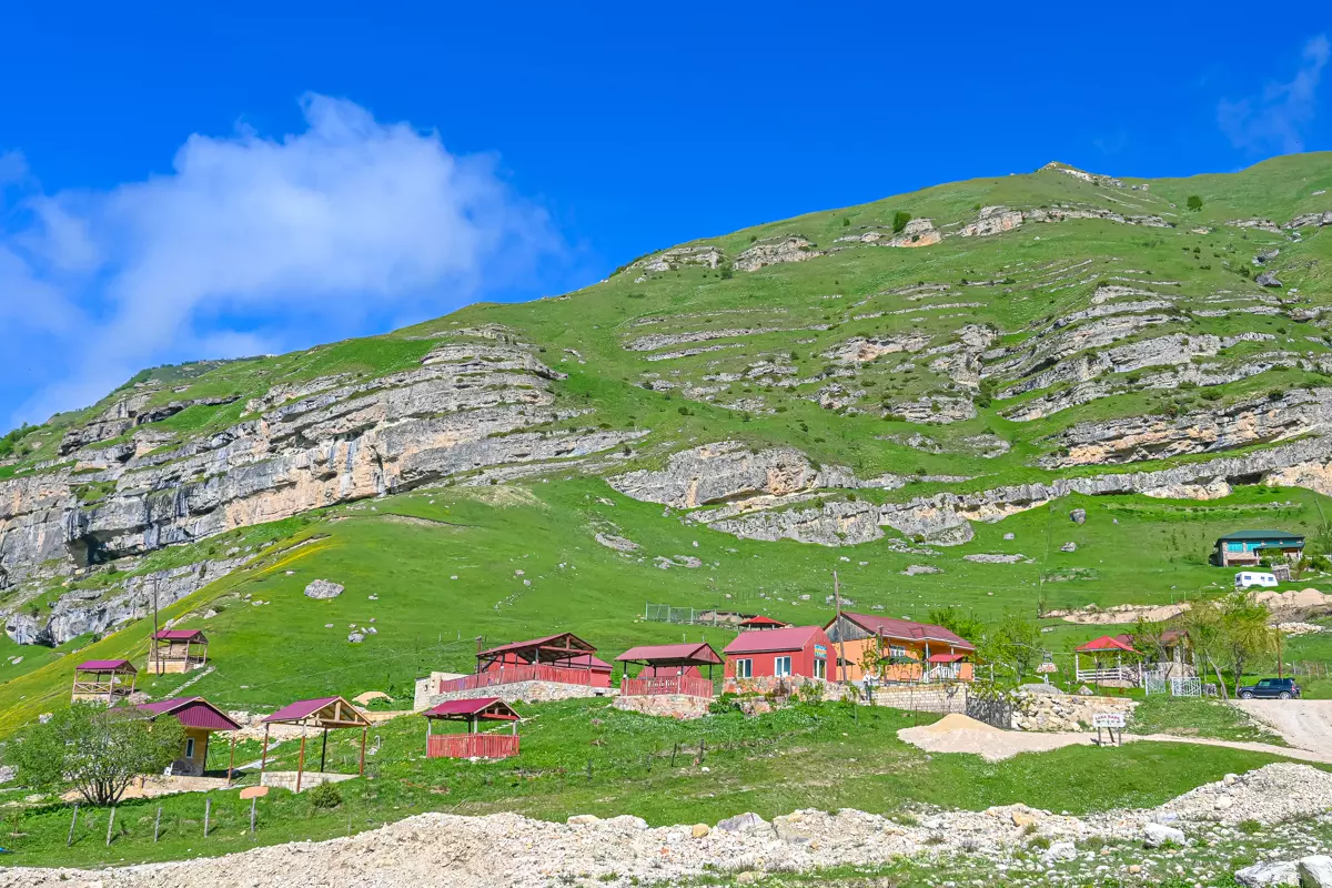 Traditional houses in Laza village surrounded by lush greenery.