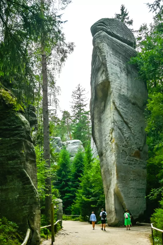Tourists standing near the Big Stone rock formation in Adrspach