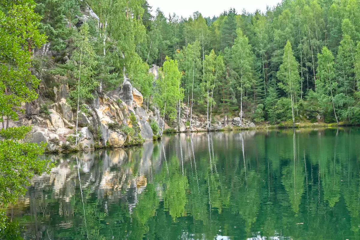 Crystal clear lake surrounded by sandstone cliffs in Adrspach