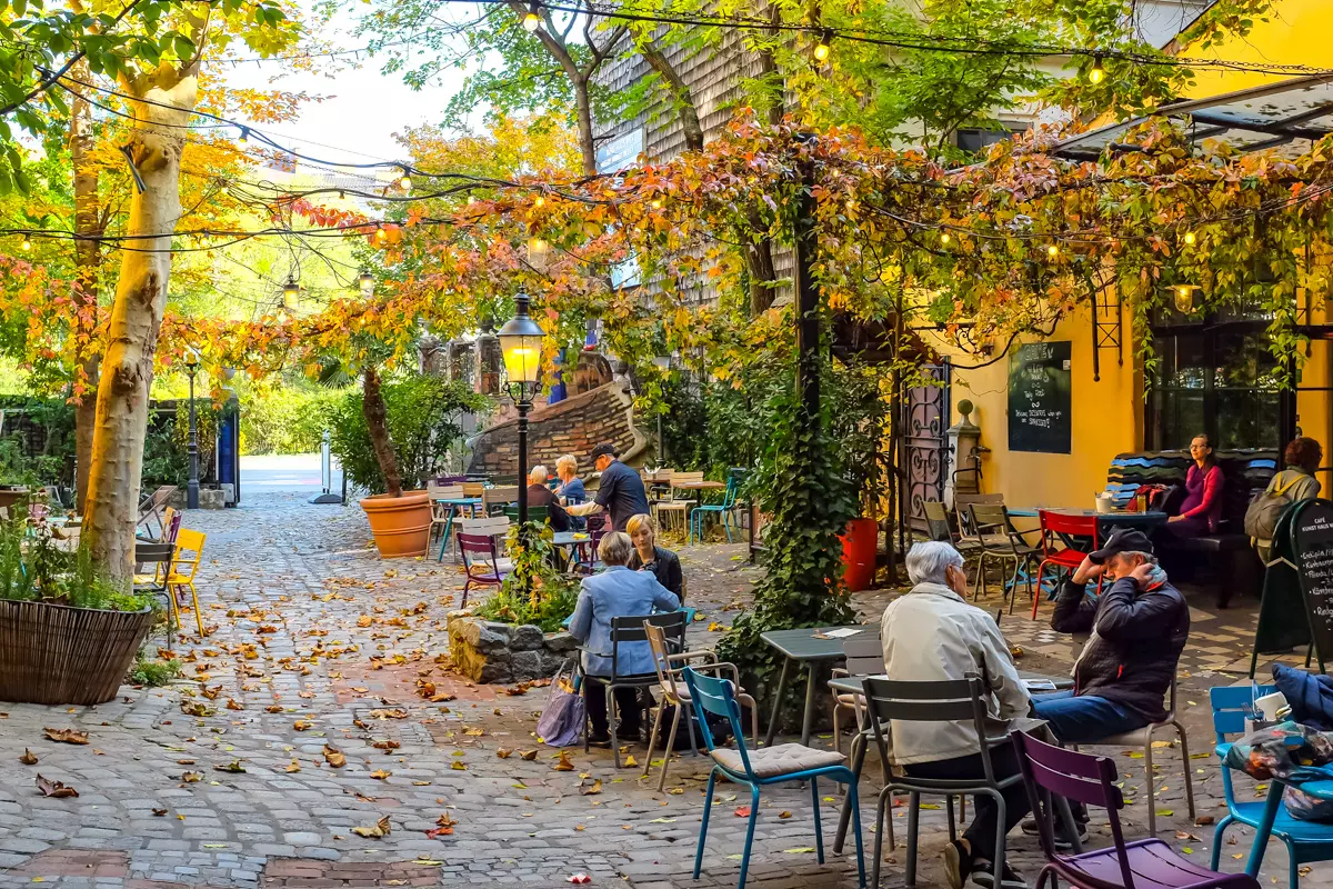 Hundertwasser Village Vienna courtyard with outdoor cafe and autumn leaves