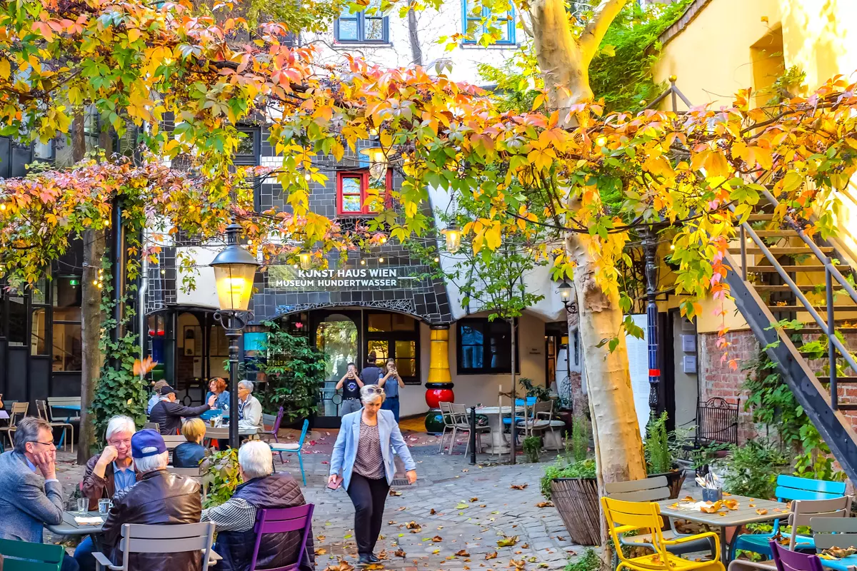 Hundertwasser Museum Vienna colorful courtyard with people sitting at outdoor cafe