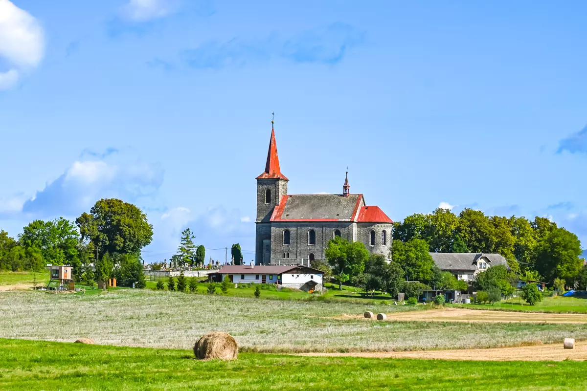 Church surrounded by countryside seen from afar in Ujezd pod Troskami