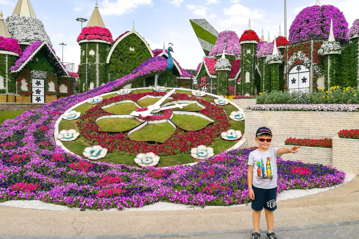 Child posing among colorful flower displays at Dubai Miracle Garden