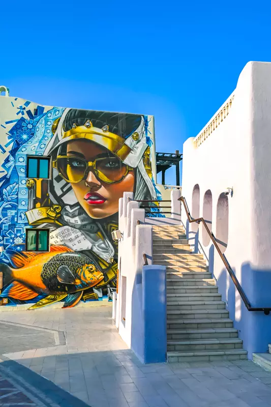 Colorful street art mural and white staircase in Mina District