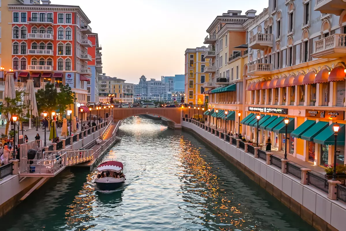 Colorful waterfront buildings and a boat on the canal at Qanat Quartier