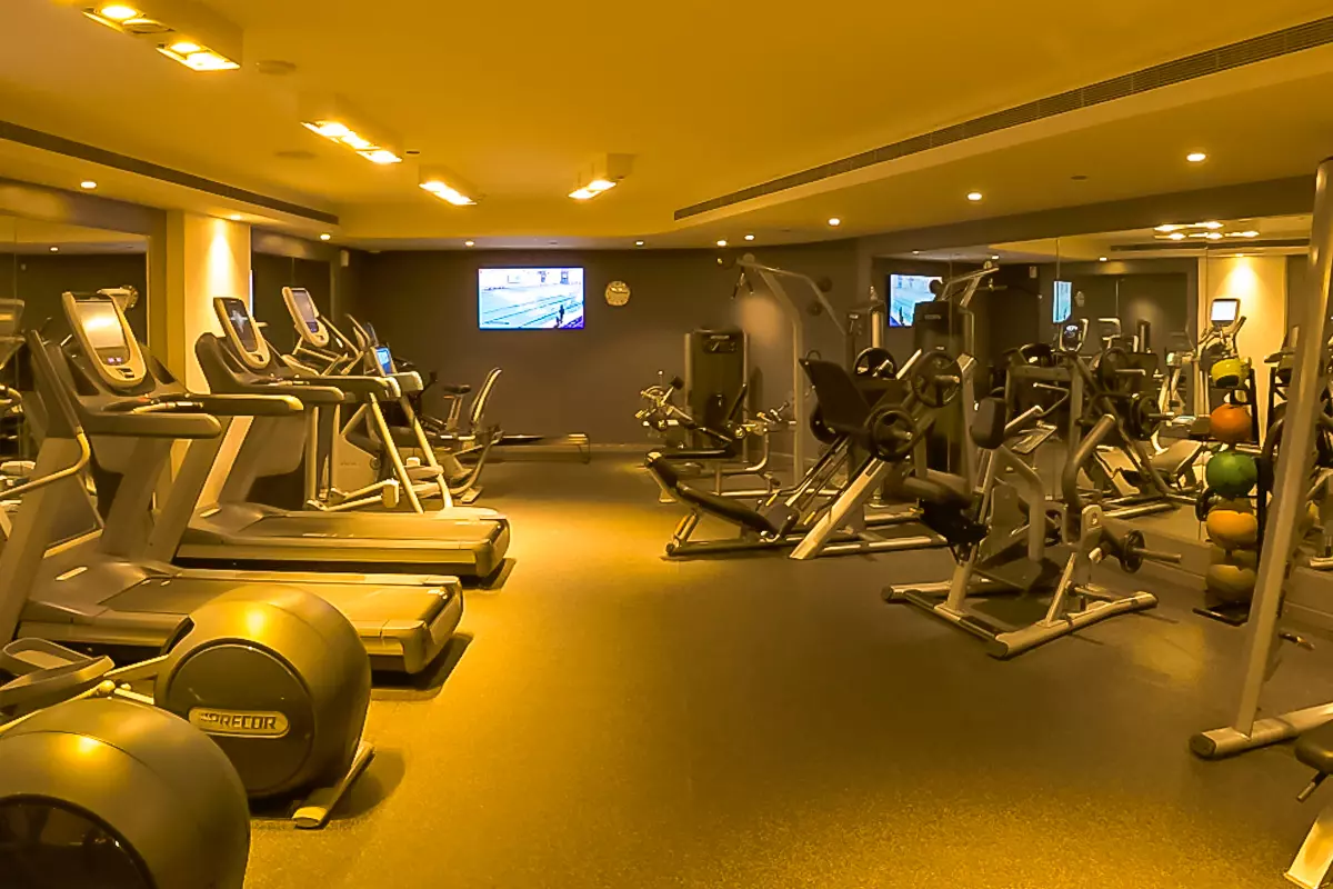 Fitness center at DoubleTree by Hilton Doha – Old Town featuring treadmills, strength training machines, free weights, and mirrored walls.