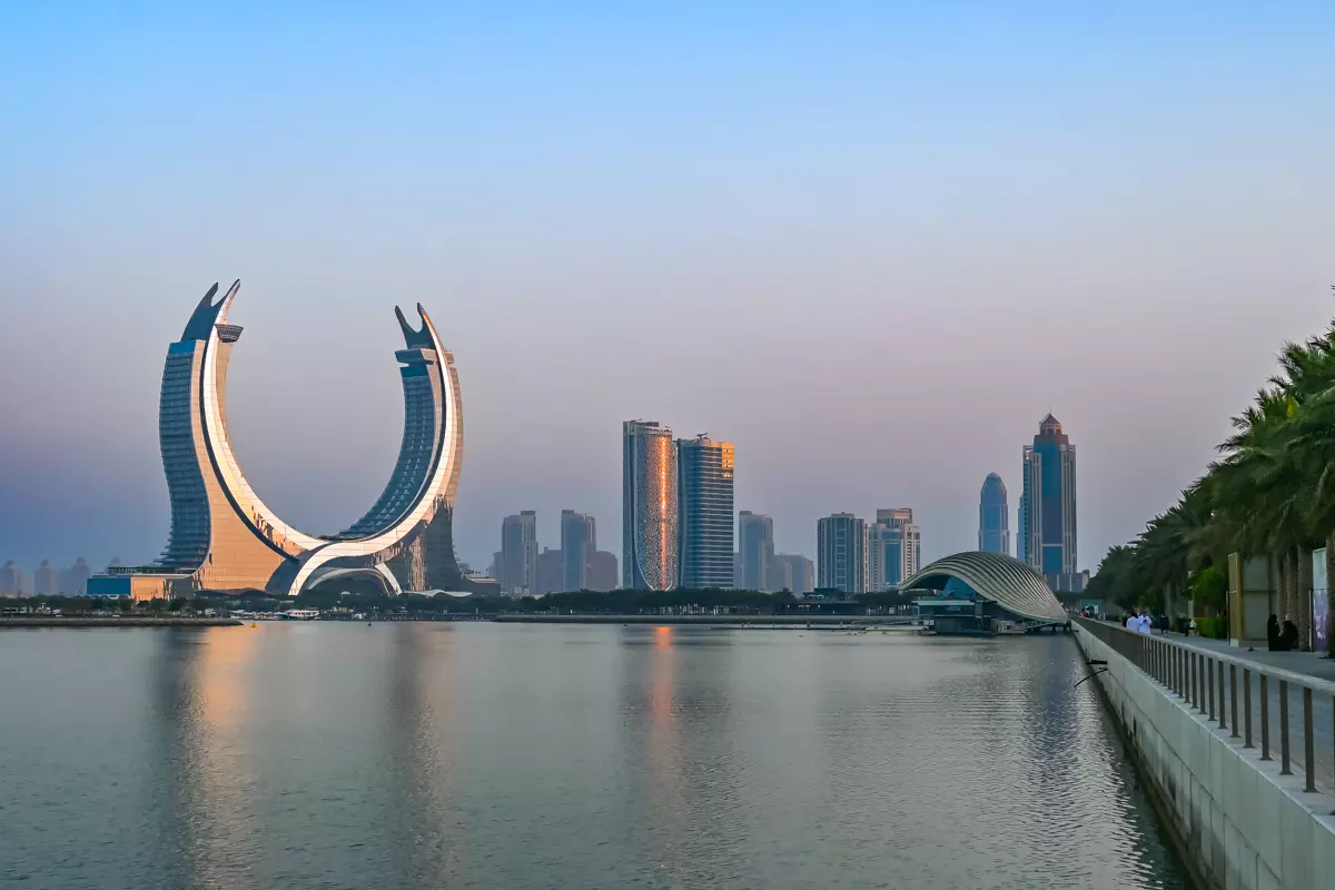 Fairmont Doha hotel building viewed across the waterfront with modern skyline in the background