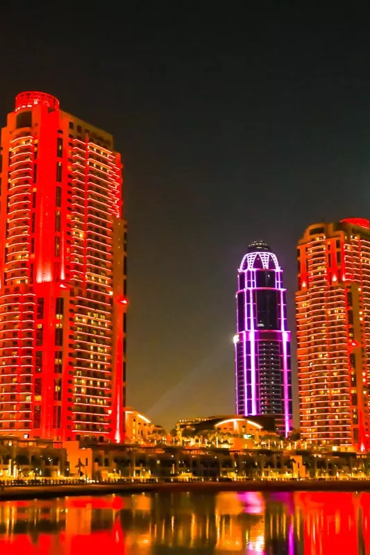 Tall illuminated towers reflecting on the water at night on Gewan Island