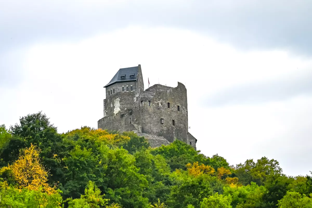 View of Hollókő Castle with stone walls and towers above the village.