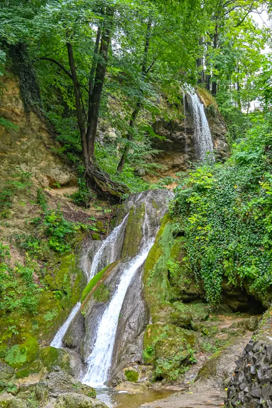 The stunning Lillafüred Waterfall cascading down a rocky cliff into a forested valley