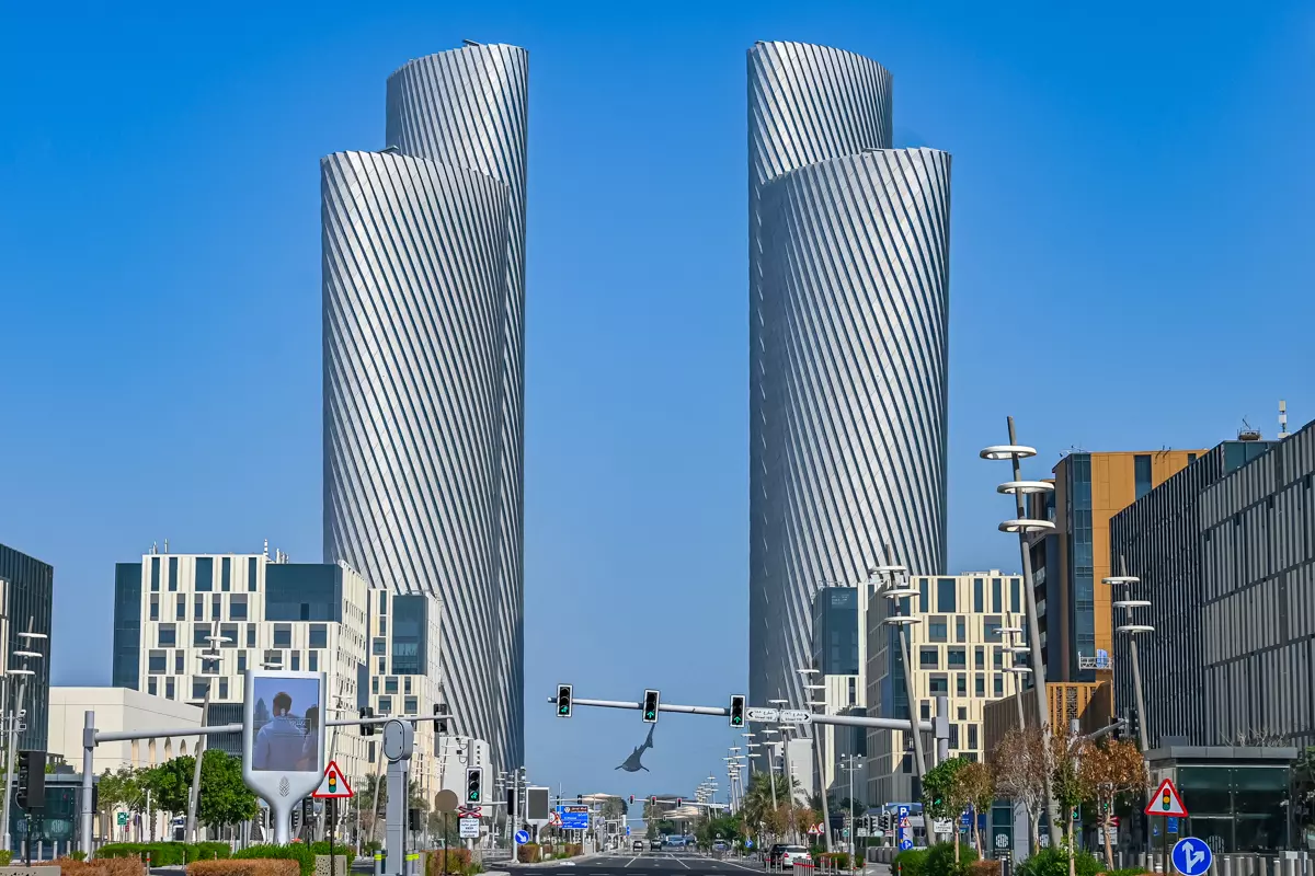 Cityscape featuring the Lusail Towers with modern high-rise buildings and a wide street view.